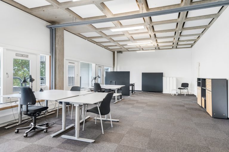 Kontor 4.16 med skriveborde, kontorstole og store vinduer